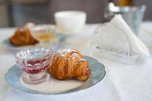 utsökt färsk croissant på en tallrik på de tabell foto