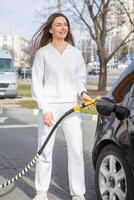 ung kvinna tankning bil med bensin på gas station. eco bränsle begrepp. de begrepp av miljömässigt vänlig transport. foto