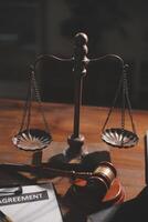 bild av domarens hammare, skalor lady av rättvisa, lag bok, bärbar dator dator och kontrakt dokument med penna begrepp av lag och rättvisa. foto