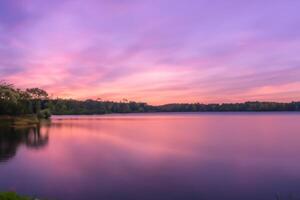 lugn vattnen en lycksalig reflexion av en skön pastell sjö och himmel, var lugn möter naturens palett, skapande en harmonisk oas av mjuk nyanser och eterisk skönhet foto