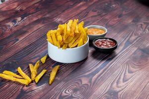 Krispig franska frites eller potatis pommes frites med mayo dopp och tomat sås eras i en tallrik sida se se foto