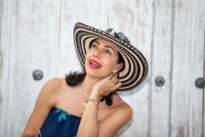 skön kvinna bär de traditionell colombianska hatt kallad sombrero vueltiao på de historisk gator av de cartagena de Indien walled stad foto