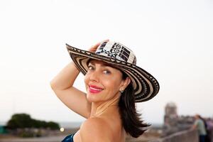 skön kvinna bär de traditionell colombianska hatt kallad sombrero vueltiao på de historisk gator av de cartagena de Indien walled stad foto