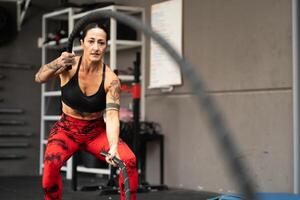 kvinna idrottare Träning i en Gym använder sig av sport Utrustning foto