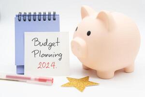 budget planera 2024 text meddelande förbi hand skrivning på papper notera, kalender, gyllene stjärna och nasse Bank. budget planera begrepp. foto