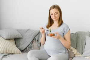 skön friska gravid kvinna äter vegetabiliska sallad foto