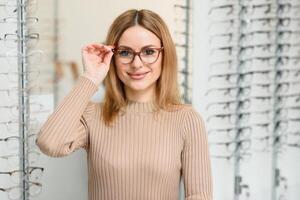 syn och syn begrepp - ung företag kvinna välja glasögon på optik Lagra. foto