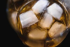 glas av scotch whisky och is över svart bakgrund foto