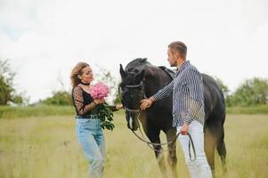 kärleksfull par med häst på ranch foto