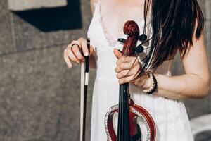 en fragment av ett elektrisk fiol, en fiol i de händer av en musikers flicka foto