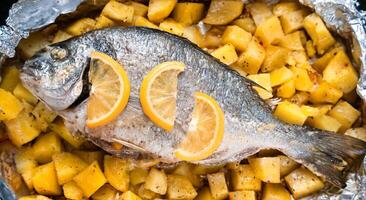 bakad fisk dorado med potatisar i de ugn. topp se. närbild. selektiv fokus. foto