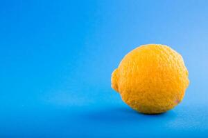 mogen gul citron- på en blå bakgrund. kopia Plats för text. foto