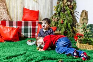 de liten barn spelar med jul dekorationer i studio, liten barn med jul boll foto