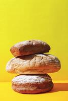 staplade surdeg bröd på gul yta foto