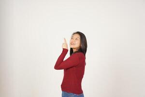 ung asiatisk kvinna i röd t-shirt pekande upp på kopia Plats isolerat på vit bakgrund foto