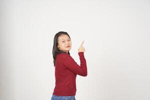 ung asiatisk kvinna i röd t-shirt pekande upp på kopia Plats isolerat på vit bakgrund foto