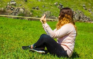 ung kvinna håller på med yoga på de gräs, ung kvinna i en fält foto
