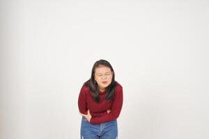 ung asiatisk kvinna i röd t-shirt lidande magont, smärta på mage isolerat på vit bakgrund foto