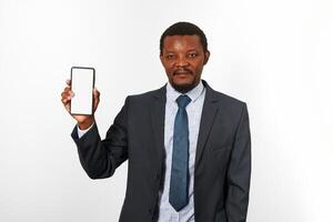 afrikansk amerikan svart man i företag kostym med smartphone attrapp i hand, vit vägg bakgrund foto