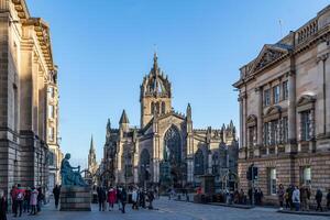 solig dag se av en livliga stad gata med historisk arkitektur och fotgängare i edinburgh, Skottland. foto