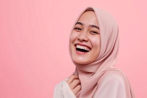 ai genererad skön ung muslim kvinna bär hijab, leende och ser på kamera på blek rosa bakgrund foto