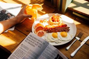 engelsk frukost med friterad ägg, bacon, korv och orange juice. foto