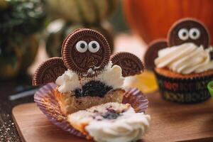 halloween muffins med rolig monster på trä- tabell. halloween fest foto