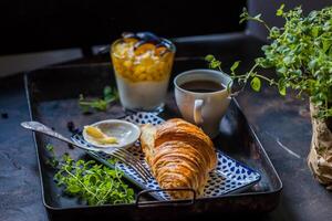 frukost med kaffe, croissant och sylt på mörk bakgrund foto