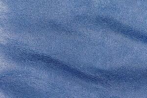 solbränd läder är målad blå. blå läder bakgrund makro. foto