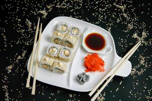 vit tallrik med sushi och ätpinnar foto