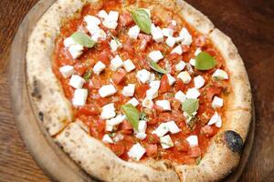 utsökt pizza med tomater, mozzarella, och basilika foto