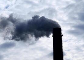 rök stack i arbetssätt växt emitterande smog och luft förorening foto