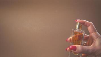 en kvinna innehar en flaska av parfym i henne hand. närbild foto