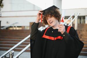 porträtt av en självsäker och glad ung examen med en diplom. man är redo för de Nästa steg i hans liv. foto