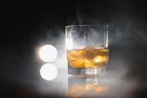 whisky glas svart bakgrund skinande foto