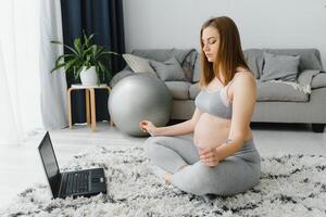 graviditet, yoga, människor och friska livsstil begrepp - Lycklig gravid kvinna mediterar på hem, vintage stil foto