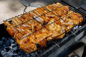 bbq picknick tid rostad kyckling ben och vingar på grill. grillning kött på utomhus- grill rutnät gott grilla kyckling biff med rök lågor saftig kött i de bakgård i sommar foto