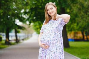 de gravid flicka på promenad i stad parkera foto