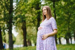 skön gravid kvinna avkopplande i de parkera foto