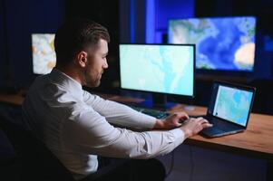 manlig data forskare Arbetar på personlig dator kontrollera och övervakning rum. Karta övervakning av människor gående på stad gator foto