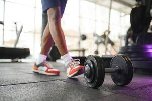 närbild av en man tar en hantel i de Gym foto