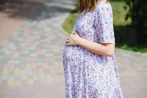 de gravid flicka på promenad i stad parkera foto