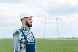 porträtt av ingenjör nära överföring rader. energi effektivitet uppfattning. överföring torn foto