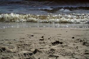 våt sand och mjuk vågor på en strand. foto