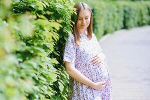 de gravid flicka på promenad i stad parkera foto