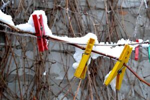 kläder pinnar täckt förbi snö på de rep utomhus. foto