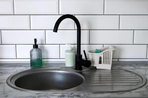 svart kran och handfat med tvål i kök. kök interiör. foto
