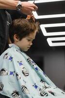 glad caucasian pojke få frisyr i frisör. foto