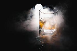 whisky glas svart bakgrund skinande foto