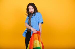 Gay man håll regnbåge randig flagga isolerat på färgad bakgrund studio porträtt. människor livsstil mode lgbtq begrepp foto